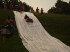 some people are sliding down a hill with an inflatable tube attached to it