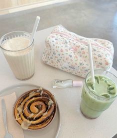 a table topped with a plate of food next to a cup of milkshake