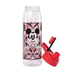 a bottle with a toothbrush in it next to a mickey mouse design on the lid