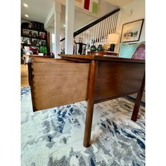 a wooden table sitting on top of a carpet covered floor