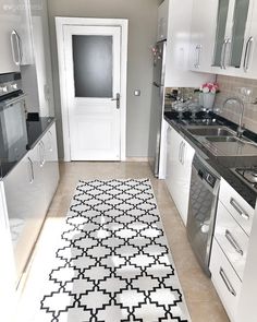 a black and white rug in a kitchen with an oven, dishwasher and sink