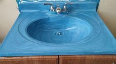 a blue sink sitting on top of a wooden cabinet