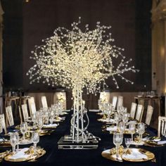 the centerpiece is made out of branches with lights in them and sits on a black table cloth