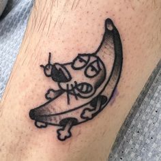 a black and white tattoo on the leg of a man with a banana in it