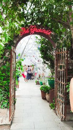 a woman standing in front of an archway that says the grandios on it's side