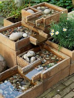 several wooden boxes filled with rocks and flowers