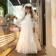 Whether you prefer a classic white ensemble or opt for subtle pastel shades, choosing a first communion dress with sleeves and a veil allows you to strike the perfect balance between tradition and contemporary style. Let your little one shine on her special day while feeling confident and beautiful in an outfit that captures the essence of this cherished celebration. First Holy Communion Dresses, Lace Flower Girl Dress, Holy Communion Dresses, Ivory Flower Girl, Ivory Flower Girl Dresses, First Communion Dress, Wedding Flower Girl Dresses, Flower Girl Dress Lace, Feeling Confident