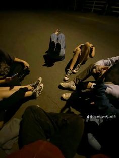 four people sitting on the ground with their feet up