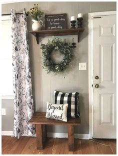 a wooden bench sitting in front of a door with a wreath on top of it