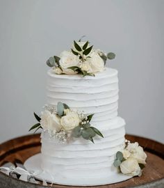 a wedding cake with white flowers and greenery