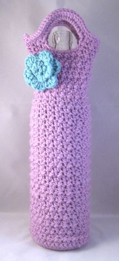 a crocheted water bottle cover with a flower on it