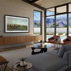 a living room filled with furniture and large windows overlooking the mountain range in the distance