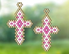 two pink and white cross shaped pixelated objects on green grass with trees in the background