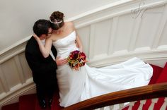 the bride and groom are kissing on the stairs