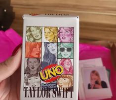 someone holding up a uno tatlowshirt box with pictures on it and the word uno