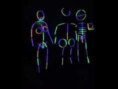 two people standing next to each other in the dark with neon lights on their bodies