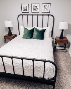 a white bed with two nightstands next to it and some pictures on the wall