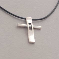 "Rejoice in your commitment to the faith with this modern cross necklace. Wear your Christianity with pride and show the world the beauty that lies within each time you get dressed. This modern cross necklace is custom handmade in majestic detail from sterling silver. Polished to a brilliant shine, it is suspended from a length of black leather cord to complete the look. It makes a fabulous gift and will be a heartwarming addition to his existing jewelry collection. Cross measures 3.4 cm x 2.5 c Modern Crucifix Cross Necklace As Gift, Modern Cross Necklace As A Gift, Cuttlefish Casting, Sterling Silver Cross Necklace, Sunflower Jewelry, Silverware Jewelry, Golden Jewelry, Cross Paintings, Christian Jewelry