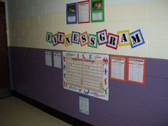 a bulletin board with words and pictures hanging on it's wall in a school hallway