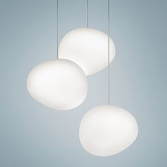 three white lights hanging from the ceiling against a blue sky