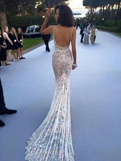 the back of a woman's dress with people standing in the background and onlookers