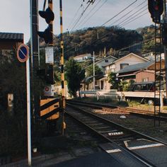 the train tracks are running parallel to each other and there is a stop light at the end