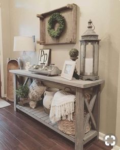 a table with some pictures and other items on it in front of a wall hanging