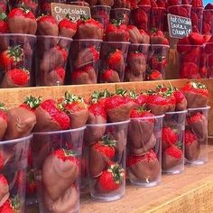 chocolate covered strawberries in plastic cups on display