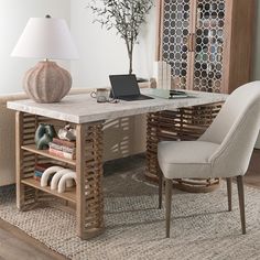 a laptop computer sitting on top of a wooden desk next to a chair and lamp