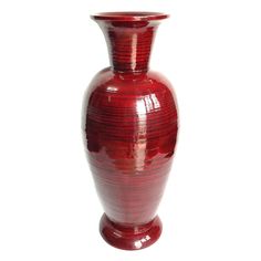 a large red vase sitting on top of a white table