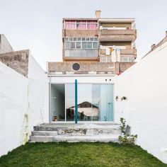 an apartment building that is next to a grassy area with stairs leading up to it