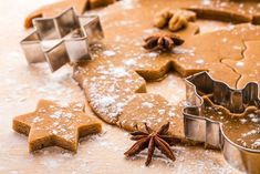 cookie cutters and star shaped cookies on a table with other baking ingredients around them