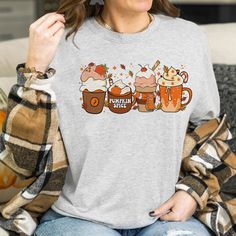 a woman sitting on a couch wearing a t - shirt with three mugs of beer