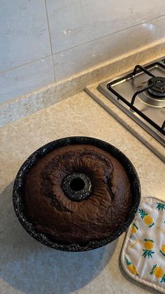 a bundt cake sitting on top of a kitchen counter next to a pot holder