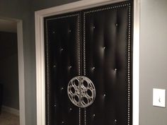 a black door with silver studs and a circular design on it