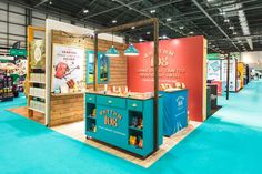 an exhibit booth with various items on display in the center and blue carpeted flooring