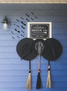 the brooms and hats are hanging on the blue wall with bats in the background