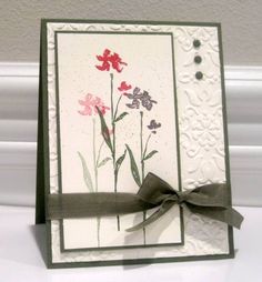 a close up of a greeting card with flowers and a bow on the front side