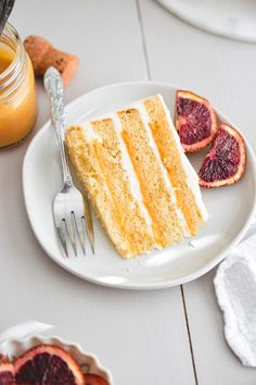 a piece of cake on a plate with a fork and orange juice in the background