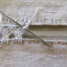 a close up of a piece of fabric with a needle in it and some stitches on the side