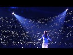 a woman standing on top of a stage with lights