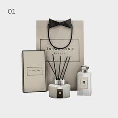 an assortment of perfumes and accessories are displayed in front of a white box with the words joli de vivre on it