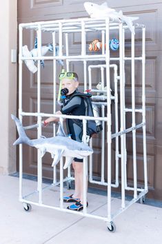 a young boy standing in front of a door wearing a scuba suit and goggles