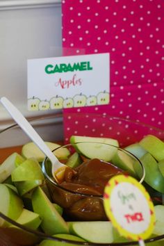 apples and caramel are in a bowl on the table