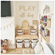 there is a play area with toys and books in the corner, along with other storage bins