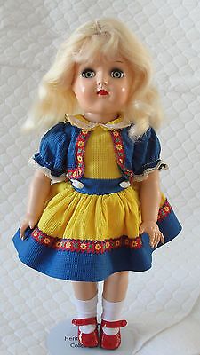 a doll with blonde hair wearing a yellow dress and red shoes on a white background