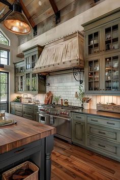 a large kitchen with wooden floors and green cabinetry, along with an island in the middle