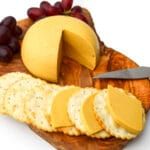 cheese, crackers and grapes on a wooden platter