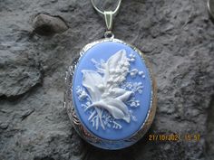 "Beautiful cameo locket. The cameo is a gorgeous lily of the valley. Stunning colors. I have this in so many colors, finishes and styles so please do browse. The bronze or silver locket is Victorian style with beautiful etching on the front and back about 2\" long, please see the photo for size. It can hold two photos or a treasured keepsake. Pass down from generation to generation. The chain is 24\" bronze link chain with a lobster claw clasp. For the silver is a 24\" silver plated snake chain. Blue Locket Necklace For Wedding, Blue Medallion Necklace For Wedding, Blue Medallion Necklaces For Wedding, Blue Cameo Jewelry For Wedding, Blue Locket Jewelry For Wedding, Blue Wedding Locket Jewelry, Blue Cameo Necklace For Wedding, Flower Shaped Locket Jewelry For Wedding, Floral Wedding Locket Jewelry