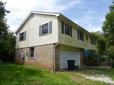 a two story house with a garage in the front yard and trees on either side